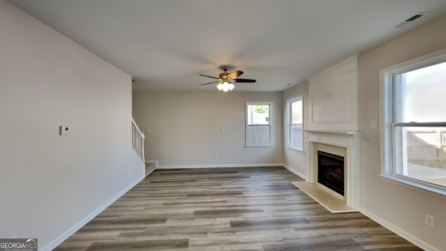 unfurnished living room featuring ceiling fan and light wood-type flooring