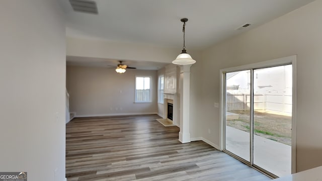 unfurnished living room with ceiling fan and light hardwood / wood-style flooring