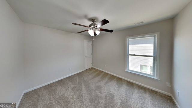 carpeted spare room with ceiling fan