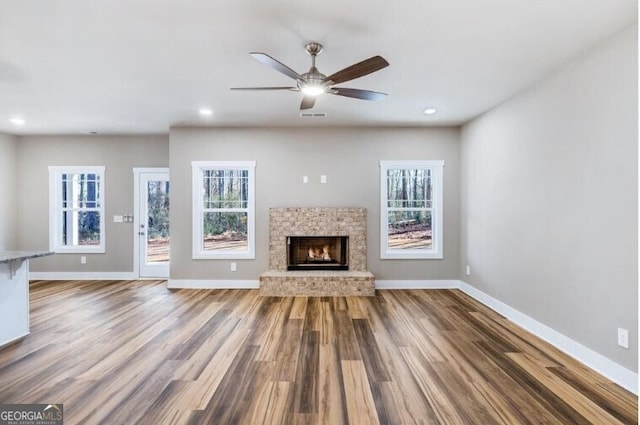 unfurnished living room featuring hardwood / wood-style flooring, plenty of natural light, and a fireplace