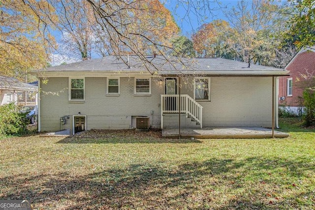 rear view of property with a yard and central AC