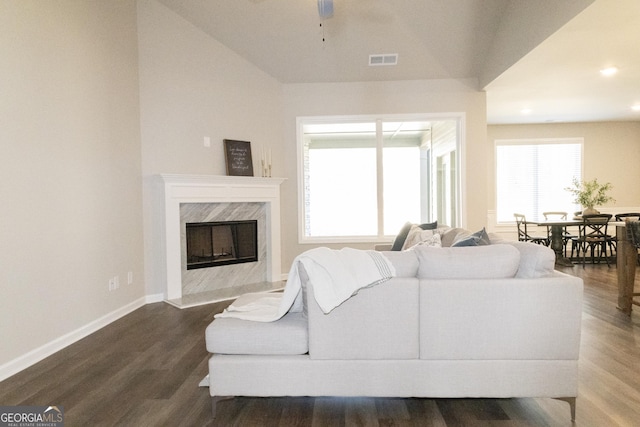 living room with a fireplace, visible vents, dark wood-type flooring, a ceiling fan, and baseboards