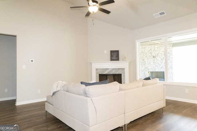 living area featuring dark wood-style flooring, a fireplace, visible vents, and baseboards