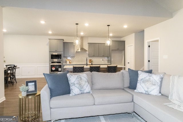 living area featuring a wainscoted wall, a decorative wall, wood finished floors, and recessed lighting