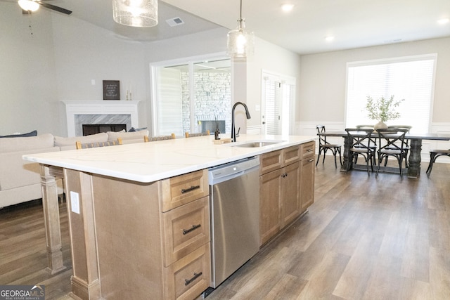 kitchen featuring hanging light fixtures, a center island with sink, open floor plan, and stainless steel dishwasher