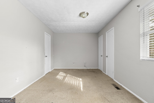 unfurnished bedroom featuring carpet flooring and a textured ceiling