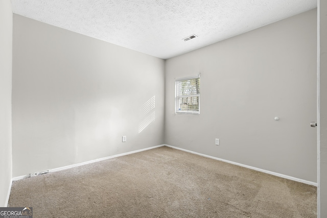 carpeted spare room with a textured ceiling