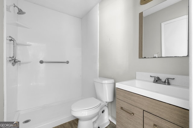 bathroom featuring hardwood / wood-style flooring, vanity, toilet, and a shower