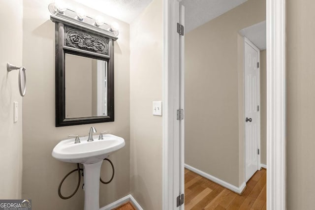 bathroom with hardwood / wood-style flooring and a textured ceiling