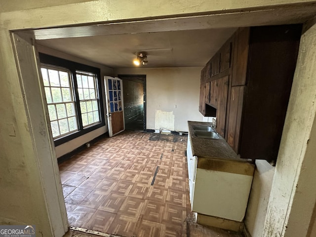 kitchen featuring sink, light parquet flooring, and dark brown cabinets