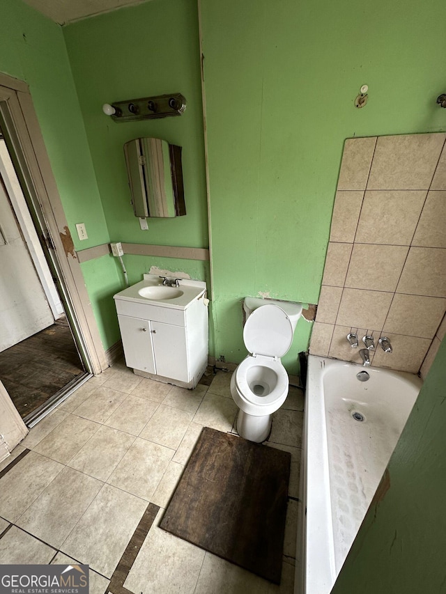 bathroom featuring vanity, a bathtub, tile patterned flooring, and toilet