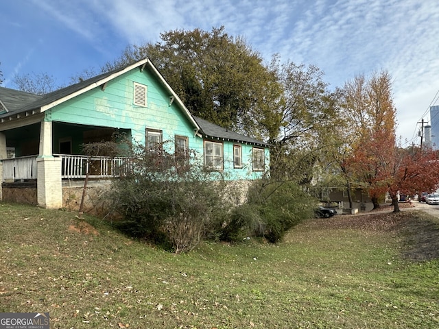 view of side of property with a yard and a porch