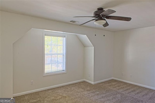 bonus room with ceiling fan and light carpet