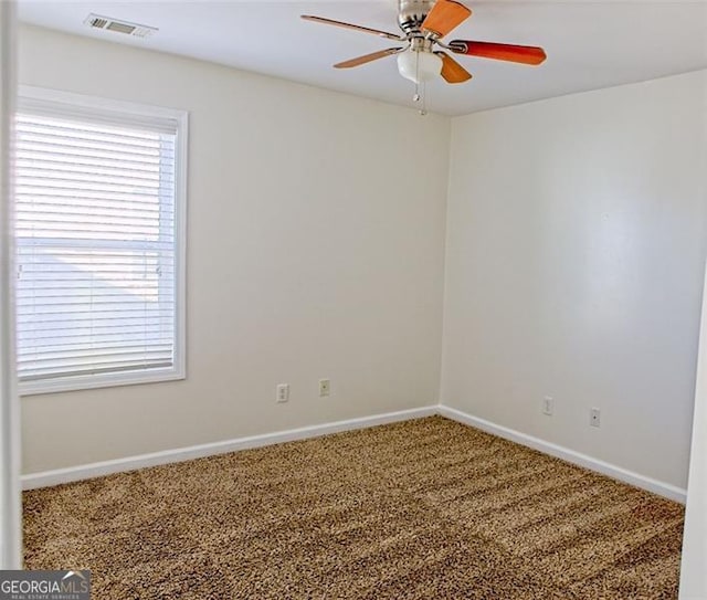 carpeted spare room featuring ceiling fan