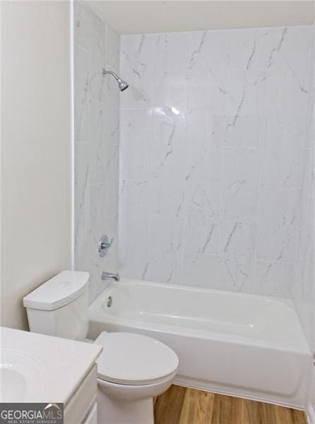 full bathroom featuring vanity, wood-type flooring, tiled shower / bath combo, and toilet