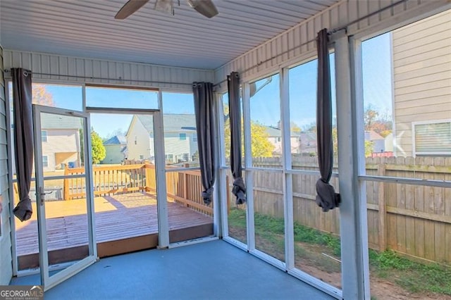 unfurnished sunroom featuring ceiling fan