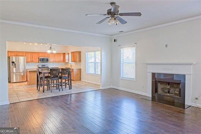 living room with ceiling fan, light hardwood / wood-style floors, and ornamental molding