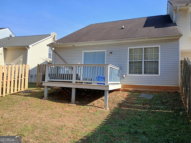 rear view of property with a yard and a wooden deck