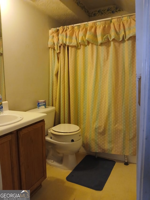 bathroom featuring vanity, a textured ceiling, and toilet