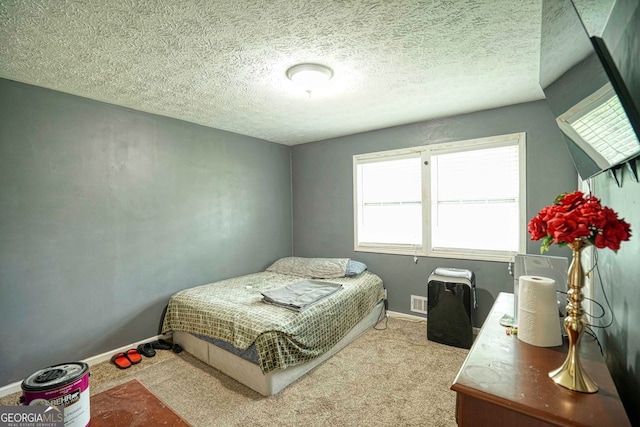 bedroom featuring a textured ceiling and light carpet