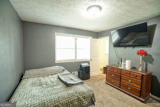 bedroom featuring light carpet and a textured ceiling