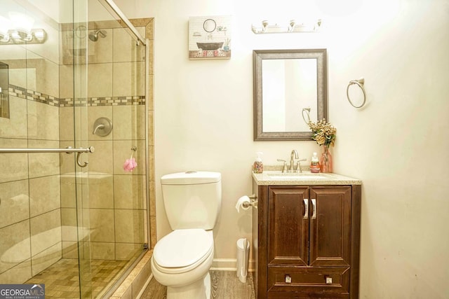 bathroom featuring vanity, toilet, and an enclosed shower