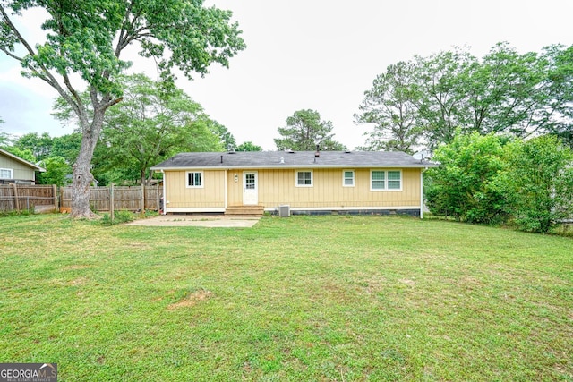 rear view of property with a yard and cooling unit