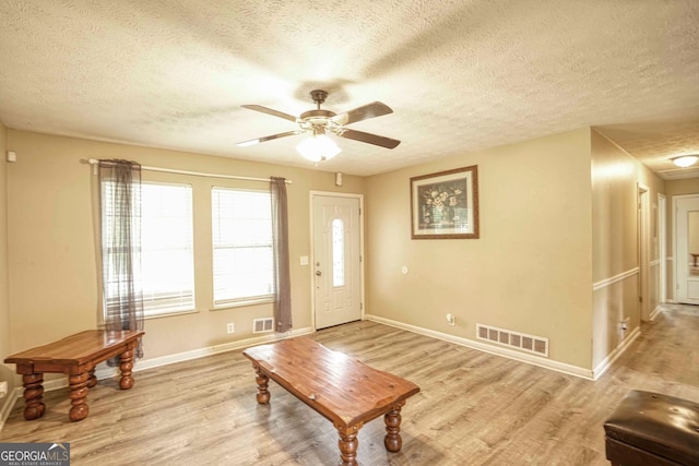 foyer with ceiling fan, light wood-type flooring, and a textured ceiling