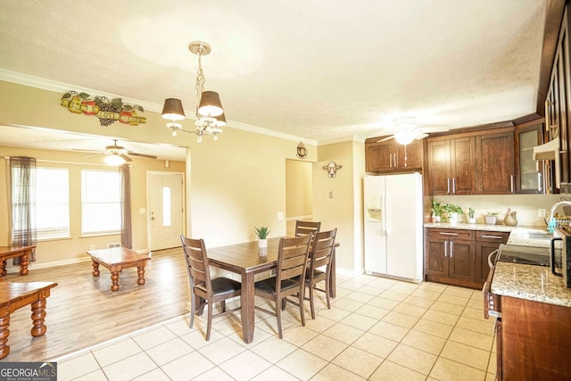 tiled dining area featuring a textured ceiling, an inviting chandelier, and ornamental molding