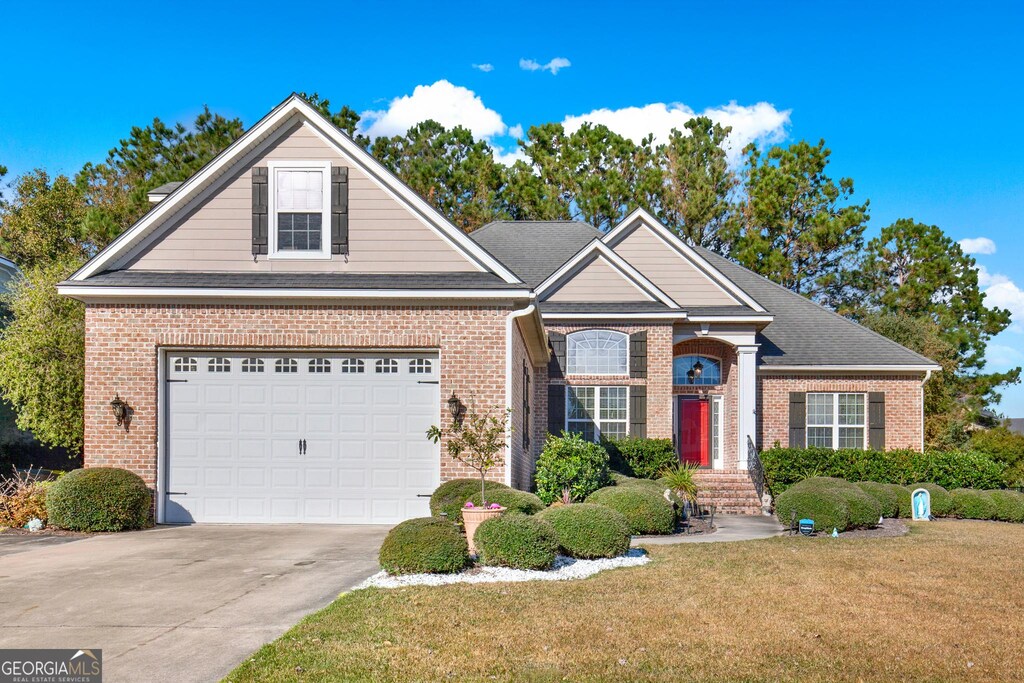 view of front of home with a front yard and a garage