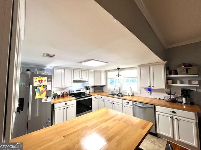 kitchen featuring stainless steel appliances, white cabinets, wooden counters, and decorative light fixtures