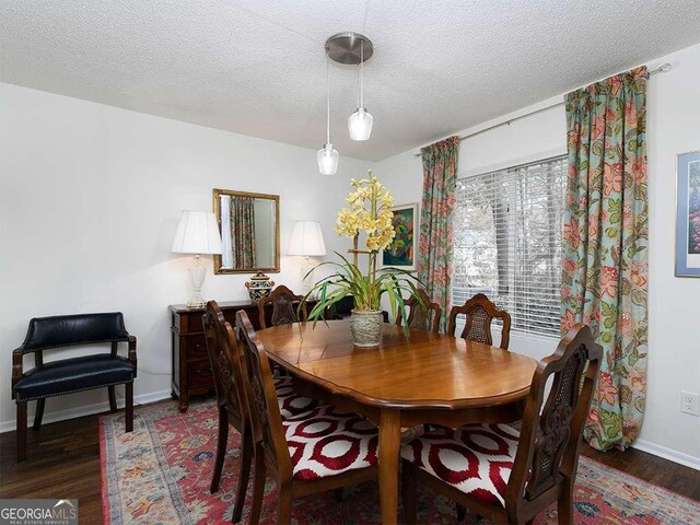 dining space featuring dark hardwood / wood-style flooring and a textured ceiling