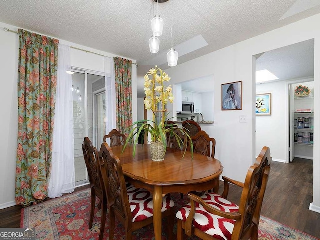 dining area with dark hardwood / wood-style flooring and a textured ceiling