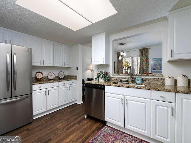 kitchen with appliances with stainless steel finishes, dark hardwood / wood-style flooring, a textured ceiling, sink, and white cabinets