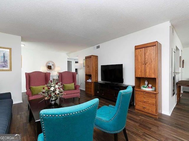 living room with dark wood-type flooring and a textured ceiling