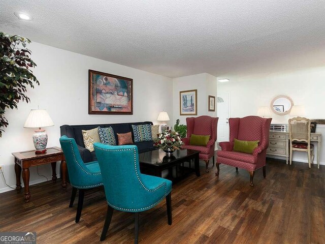 living room featuring a textured ceiling and dark hardwood / wood-style floors