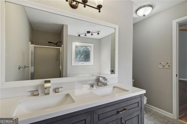 bathroom featuring tile patterned flooring, vanity, an enclosed shower, and toilet