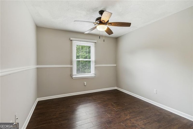 spare room with a textured ceiling, ceiling fan, and dark wood-type flooring