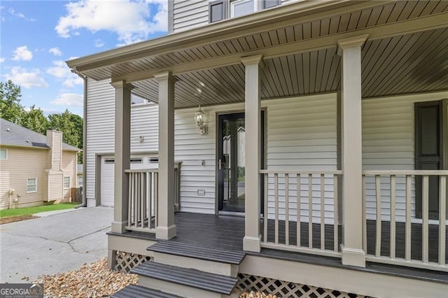 property entrance featuring a garage, driveway, and covered porch