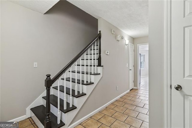 staircase featuring a textured ceiling