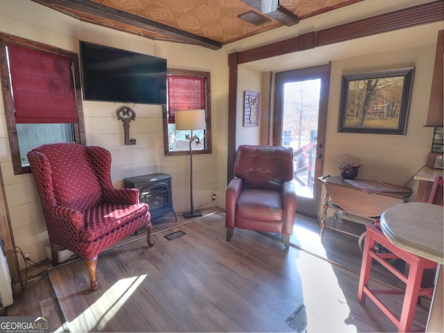 sitting room with hardwood / wood-style floors and a wood stove