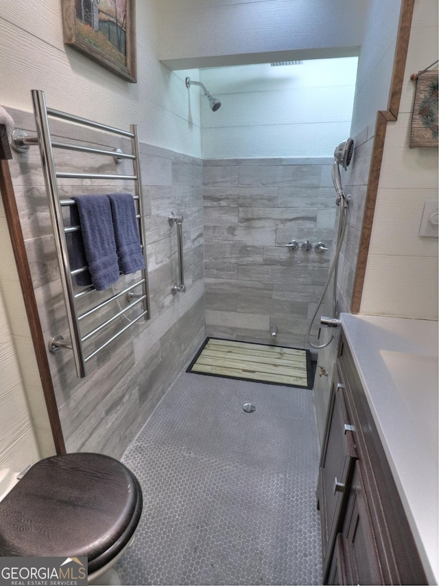 bathroom with tile patterned floors, vanity, and tiled shower