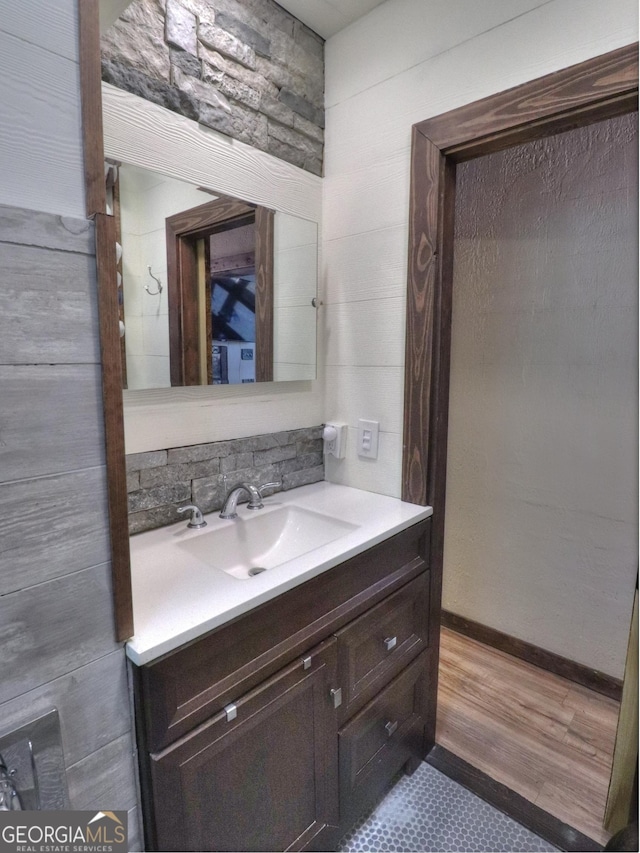 bathroom with decorative backsplash, vanity, and wood-type flooring