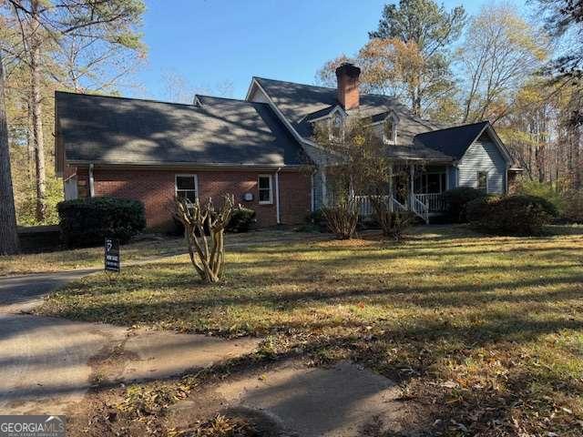 rear view of property with a lawn and a porch