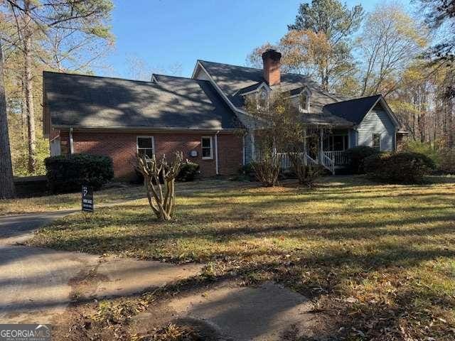 rear view of property with a lawn and a porch