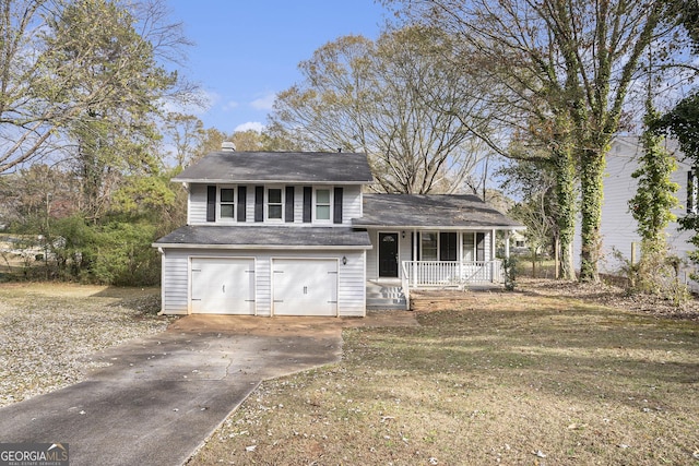 split level home featuring a front lawn, covered porch, and a garage