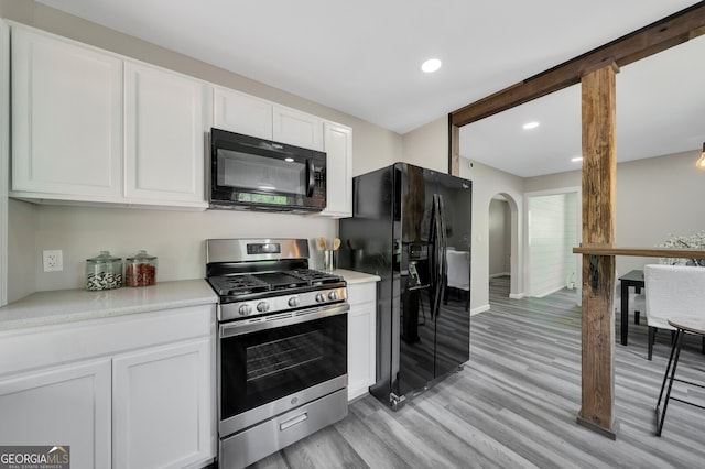 kitchen with white cabinets, light hardwood / wood-style floors, and black appliances