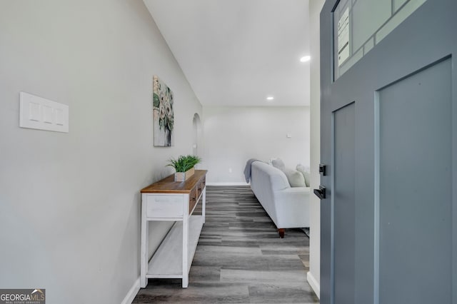 hall with a towering ceiling and dark hardwood / wood-style floors