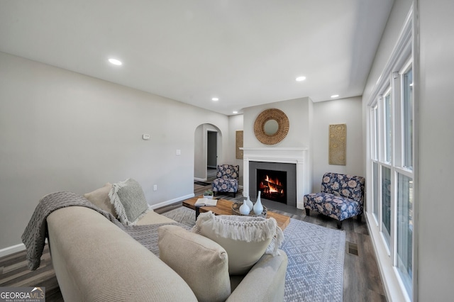 living room featuring dark hardwood / wood-style floors and a brick fireplace