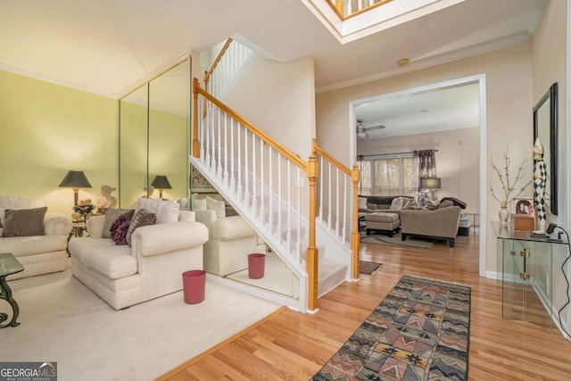 living room featuring ceiling fan, hardwood / wood-style floors, and ornamental molding